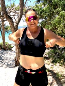 Kvinna med diabetes kan röra sig och tränar medan hon har hela diabetestillbehör i en sportsbra med fickor